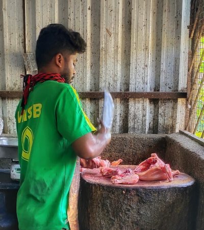 Tambaram, Chennai, India. 03-May-2020: Butcher cutting piece of chicken and customer waiting outside of the grill wall on meat shop india due to natioanl lockdown for covid-19.